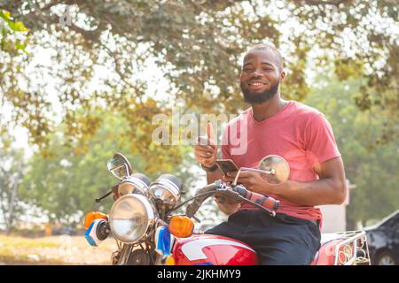 okada rider using his phone, thumbs up gesture Stock Photo