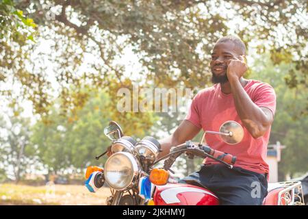 african man on a bike making phone call Stock Photo