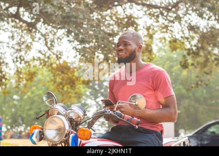 okada rider using his phone smiling Stock Photo