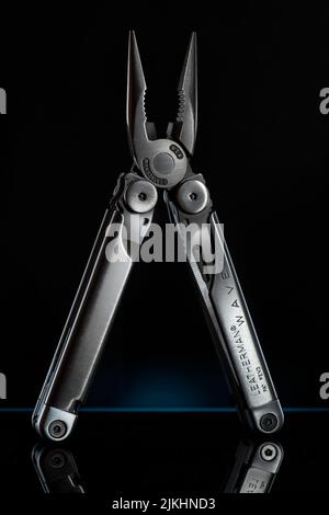 A vertical shot of sleek Leatherman Wave pliers on a dark background Stock Photo
