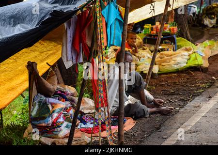 Kolhapur, India- September 13th 2019; Stock photo of 60 to 70 old Indian man sitting on street and selling cloths in the weekly market of Indian villa Stock Photo