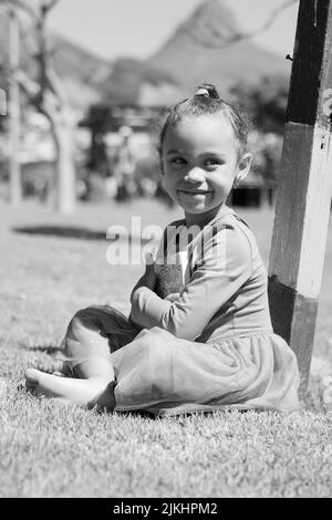 a vertical shot of small girl smiling in grayscale Stock Photo