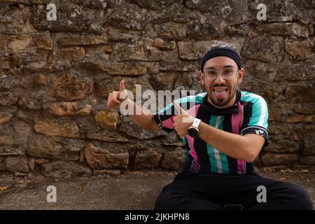 Young handsome caucasian man with dreadlocks wearing casual shirt and glasses smiling positive doing ok sign with hand and fingers. Successful express Stock Photo