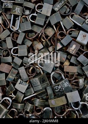 A vertical shot of a bunch of locks stacked on top of one another Stock Photo