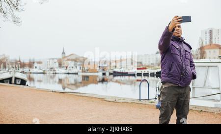 handsome Latin man in port taking picture with his mobile Stock Photo