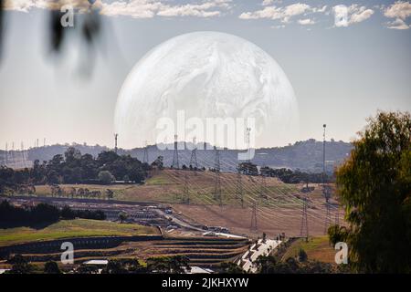 A field with a moon illustration in the background Stock Photo