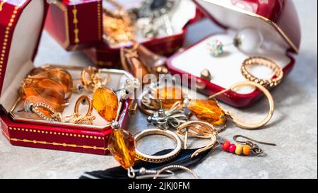 Old red boxes full of jewelry. Treasure chest, close up Stock Photo