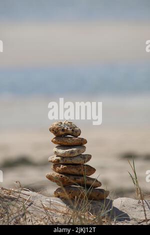 A selective focus shot of stacked stones on a sandy beach Stock Photo