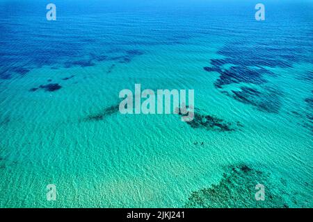 Drone point of view bright color turquoise water of Mediterranean Sea and blue cloudy sky during sunny summer day, idyllic scenery aerial shot. Costa Stock Photo
