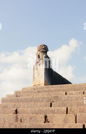 A vertical shot of the Chinese statue at the the old bridge against blue sky on a sunny day in Langde Miao Ethnic Minority Village, Guizhou, China Stock Photo