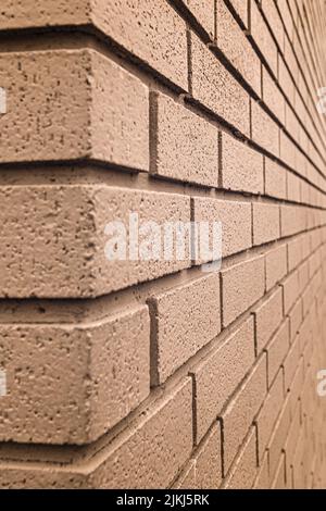 A vertical shot of a brown colored brick wall Stock Photo