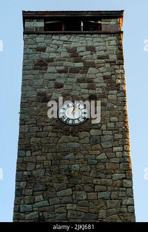 A vertical shot of a stone building with a clock on it Stock Photo