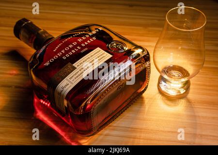 A Woodford Reserve bourbon with Glencairn glass on a wooden surface Stock Photo