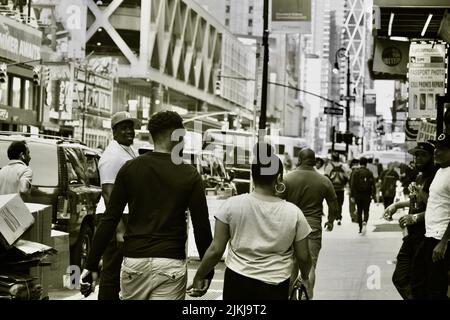 A grayscale shot of people walking in the streets of New York City. Stock Photo