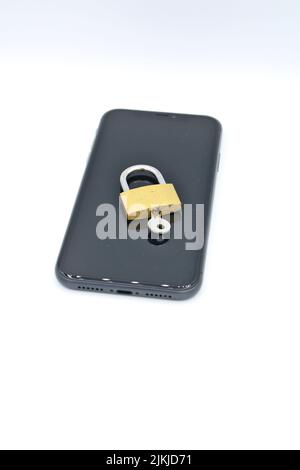 A padlock with a key on a phone- cybersecurity concept Stock Photo