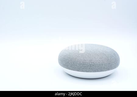 A closeup of an oval white and gray portable speaker isolated on a white background Stock Photo