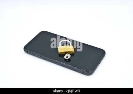 A padlock with a key on a phone- cybersecurity concept Stock Photo