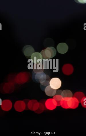 A vertical shot of colorful bokeh lights on dark background Stock Photo