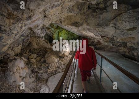 A line of tourists walking on a small bridge inside of the Demenovska cave in Slovakia Stock Photo