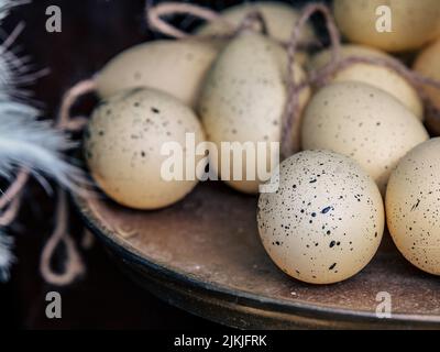 A shallow focus of spotted eggs on a platter with string, Easter preparation Stock Photo