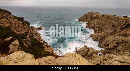 An aerial view of a beautiful stormy sea crashing on the boulders on the Mallorca coast in Spain Stock Photo