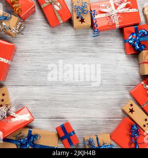 A top view of a colorful christmas presents on a wooden table with copy space in the center Stock Photo