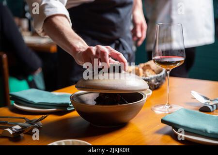 The close-up shot of a man waiter opening a dish bowl Stock Photo