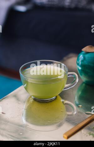 matcha green tea in clear teacup on gold table Stock Photo
