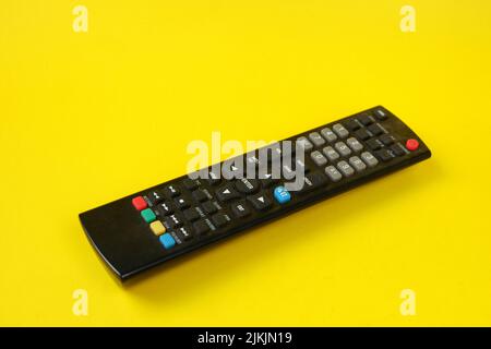 tv remote isolated on yellow background Stock Photo