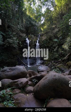 A vertical shot of waterfall flowing down lush green rock Stock Photo ...
