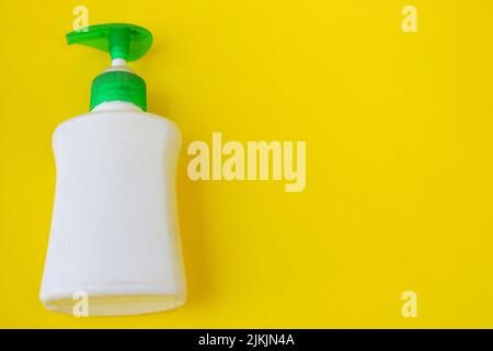 White bottle of hand sanitizer isolated on yellow background Stock Photo