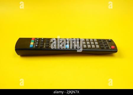 tv remote isolated on yellow background Stock Photo