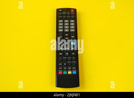 tv remote isolated on yellow background Stock Photo