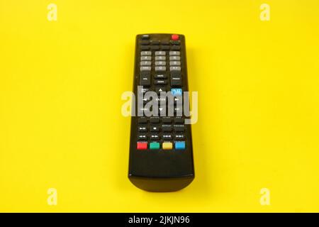 tv remote isolated on yellow background Stock Photo