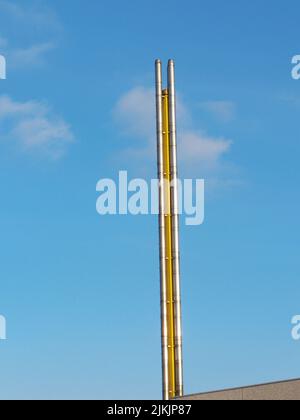 Chimney, flue pipe of a factory against a blue sky Stock Photo