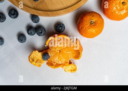 A top view of blueberries and mandarins on a white background Stock Photo