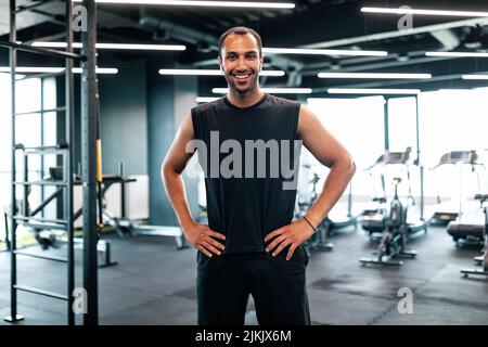 Portrait Of Handsome Black Personal Trainer Posing In Fitness Club Interior Stock Photo