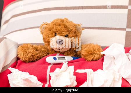 sweet little bear lies ill in a bed Stock Photo