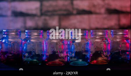 A closeup shallow focus shot of an empty gradient color glass jar on a table Stock Photo