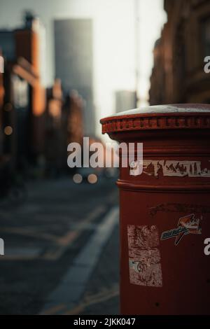A vertical shallow focus shot of a vintage red steel street mail box Stock Photo