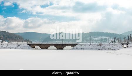 frozen snowy lake schluchsee with bridge and blue sky with clouds in the black forest Stock Photo