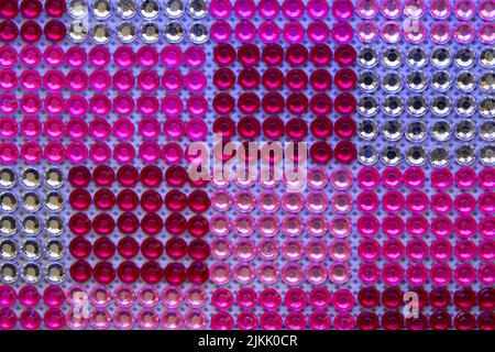 A top view of red, pink and white beads on a blue sheet Stock Photo