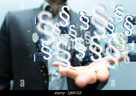 A businessman on a blurry background touching blue 3D rendering law paragraph symbols Stock Photo