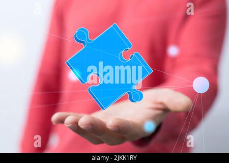 A person presenting the virtual projection of a puzzle piece Stock Photo