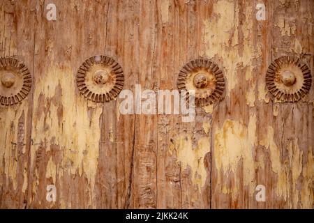 A closeup of a weathered wooden door with round decorative pattern. Stock Photo