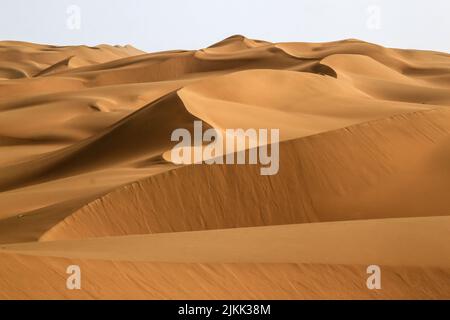 A beautiful view of the golden sand mounds on a beautiful sunny day at Kumtag Desert, Xinjiang, China Stock Photo