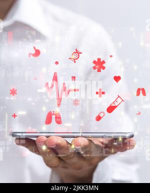 A photo of UI medical icons in hospital with a hand holding a mobile as medical technology network Stock Photo