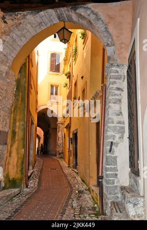 A vertical shot of a narrow cobblestone corridor path between old ...