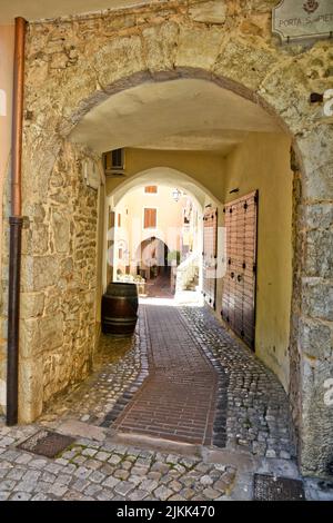 A vertical shot of a narrow cobblestone corridor path between old ...
