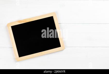 chalkboard on white wooden background with copy space Stock Photo